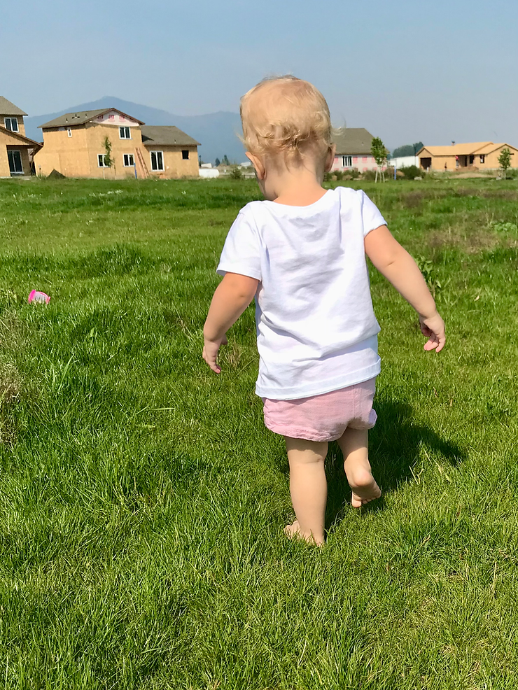 little girl walking in grass